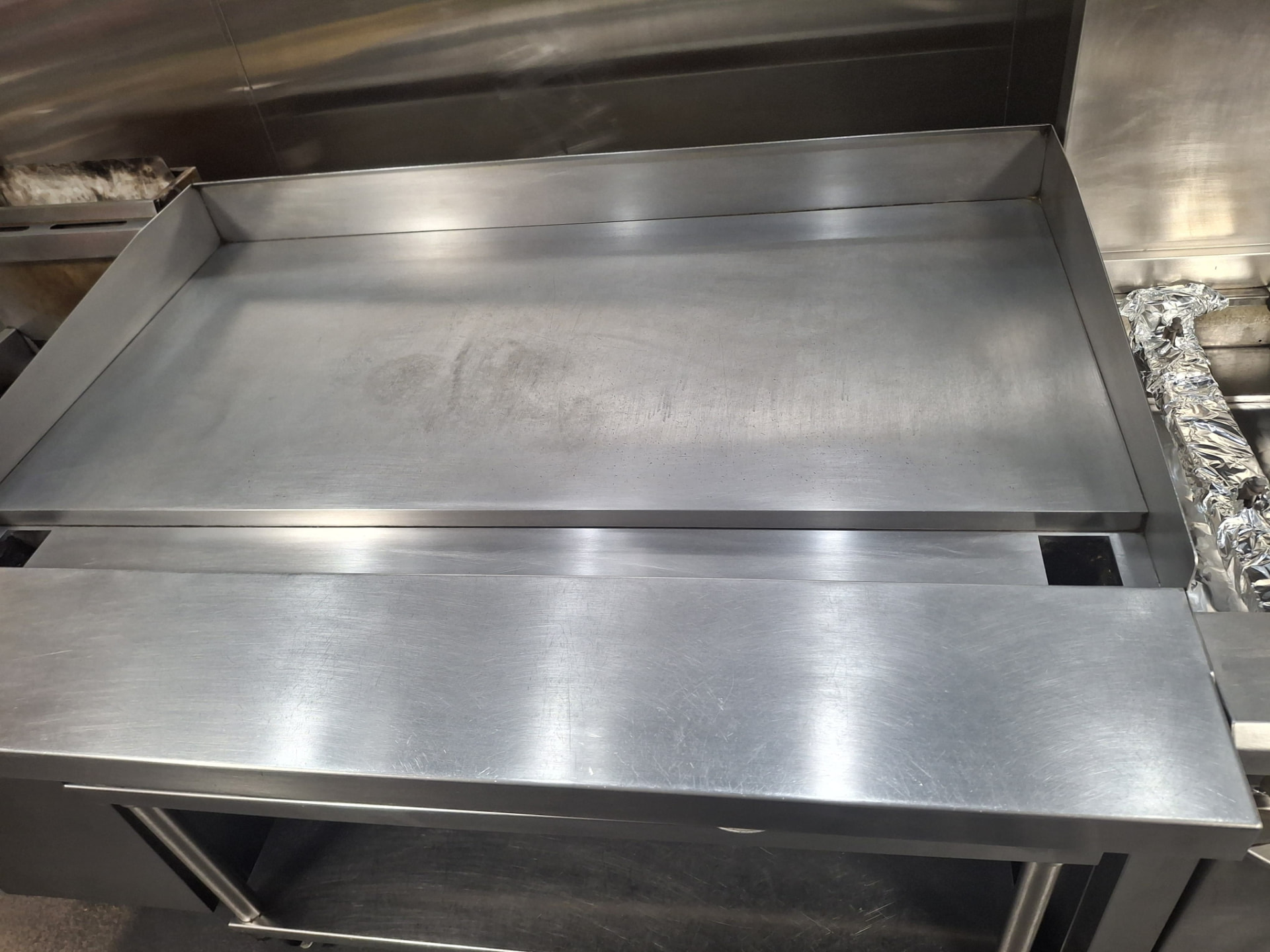 The same restaurant flat-top griddle scrubbed back to bare polished steel by Ledian's Cleaning Services