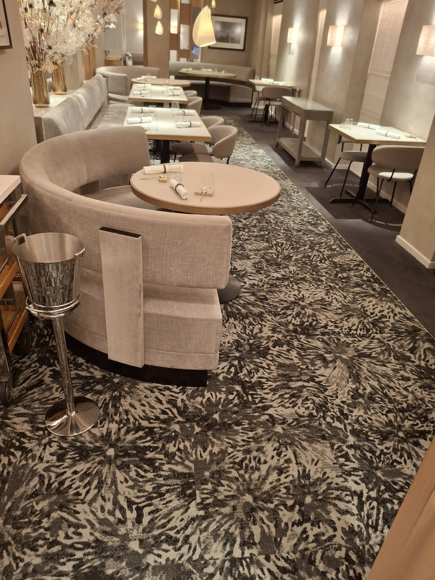 Elegant beige dining room with cleaned banquettes, set tables and vacuumed patterned carpet — Ledian's Cleaning Services