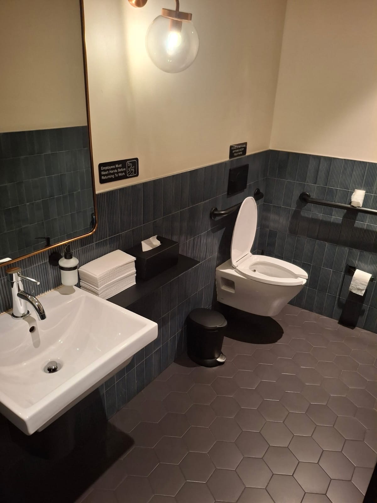 Restaurant bathroom with disinfected fixtures, scrubbed tile and polished mirrors cleaned by Ledian's Cleaning Services
