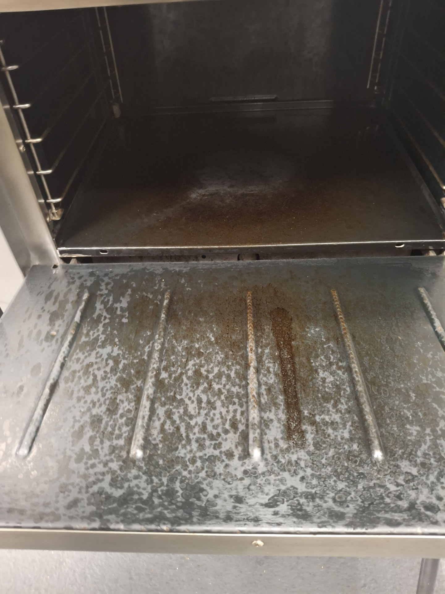 Commercial oven interior coated in baked-on grease before cleaning by Ledian's Cleaning Services