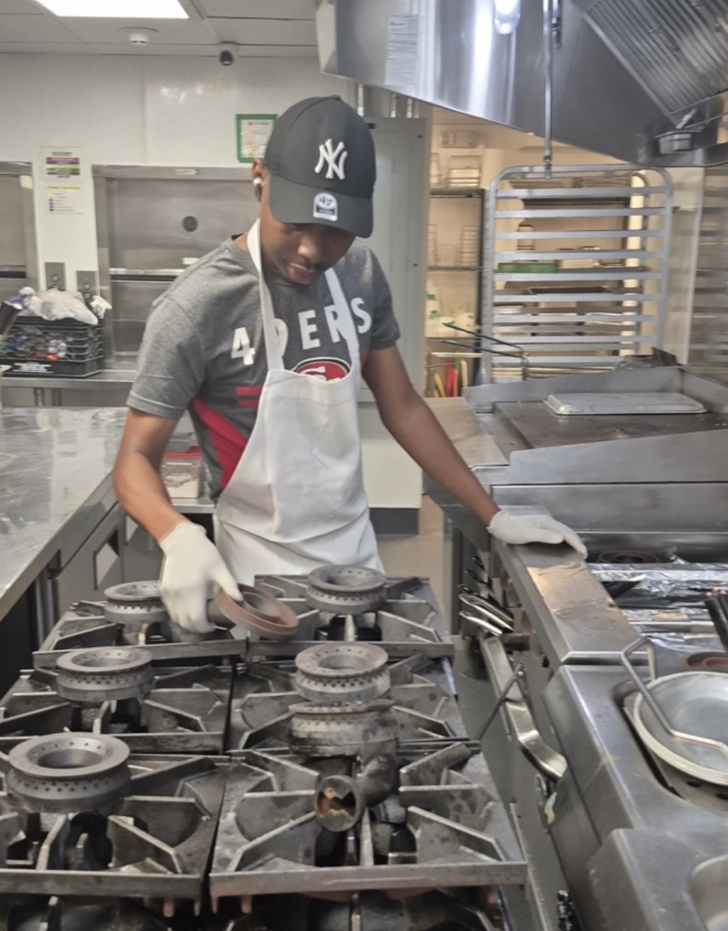 Ledian's Cleaning Services staff deep-cleaning a restaurant cooktop