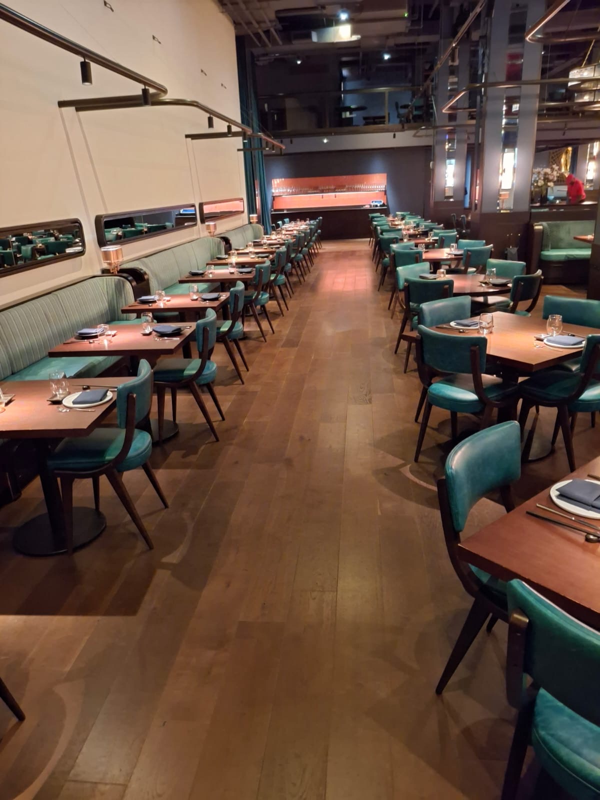 Long dining room with green upholstered chairs, wiped tables and polished wood floors — Ledian's Cleaning Services